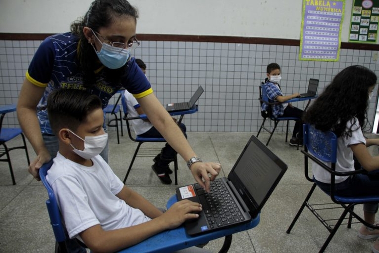 Educadora ensina criança com uso de máscara em Manaus. Foto: Divulgação