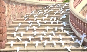Cruzes são estendidas na escadaria do Teatro Amazonas em ato contra mortes por Covid-19 