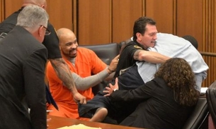 Serial killer ri após pai de vítima tentar agredi-lo em julgamento