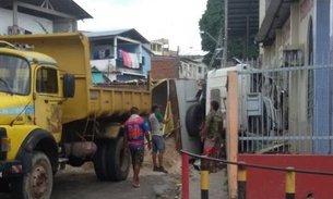 Caçamba carregada de areia bate em poste e tomba em Manaus 