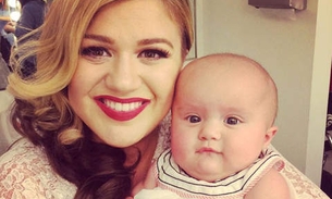 Kelly Clarkson posa com a filha em dia de gravação